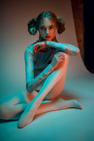 Portrait of blonde woman in blue bodysuit with mushrooms posing at cameraの写真素材