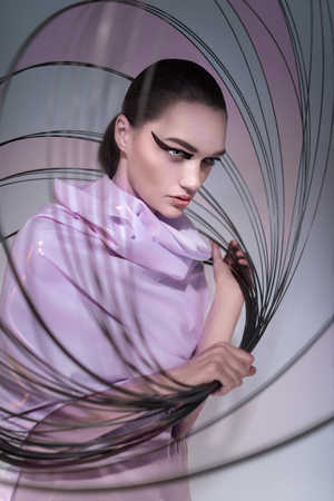 Portrait of woman in pink dress posing at camera with thin circlesの写真素材