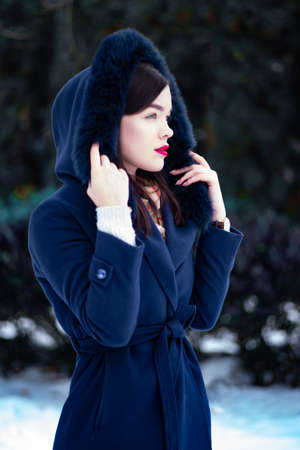 Young beautiful woman walking on street in winterの写真素材