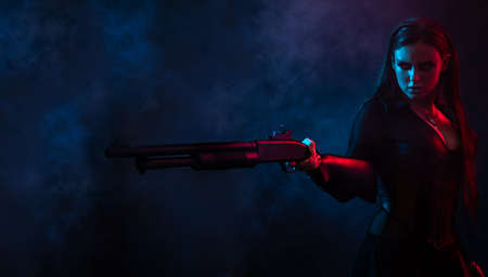 Longhair vampire in black long corset dress in smoke holding a gunの写真素材