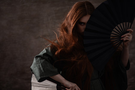 Fashion photography. Young model posing with fans in studioの写真素材