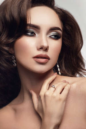 Beautiful model with fashion makeup and earings. Studio close up portraitの写真素材