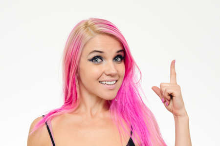 Got an Idea. Pink haired female is showing finger up as a sign of found solution. Looking to camera.の写真素材