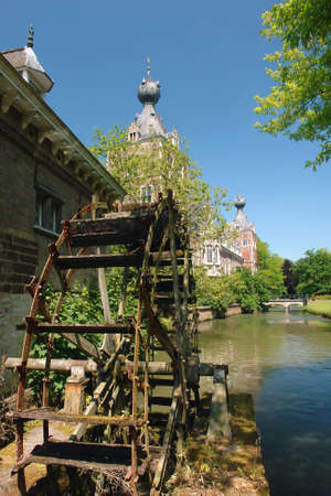 An old, aged, worn-out and rusty watermill in a park with castle near Chateau Arenbergh, Flanders, near the city of Louvain. Details of axle and wheel.の写真素材