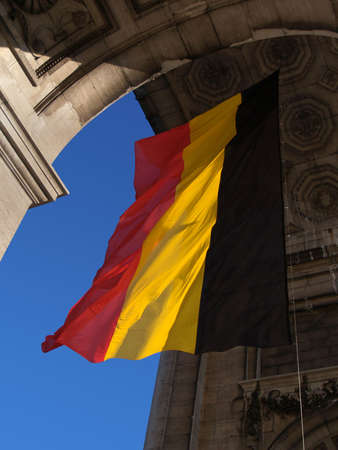 Belgian flag waving under the triumphal arch in the Parc du Cinquantenaire in Brussels.の写真素材