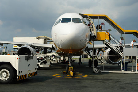 Passengers exiting commercial airliner by stairs on an airport.