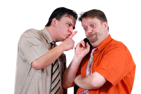 Two men conspiring and gossiping with an amazed and bewildered look, isolated over white. Business...