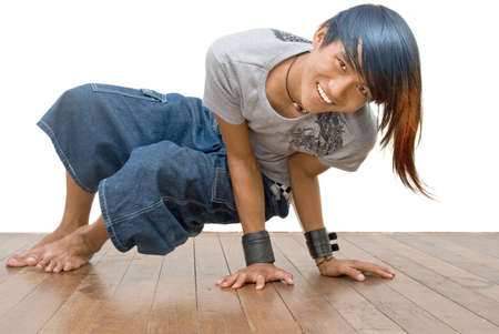 Asian active teenager in a break dancer pose, cheering and smiling, and with punk one-sided colored long hair. Emo and friendly healthy macho punker boy. Isolated over white.の写真素材