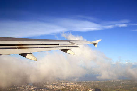 Asian aerial city view from within a commercial airplane right after take-off, with wing in view. Cagayan de Oro, Philippines.の写真素材