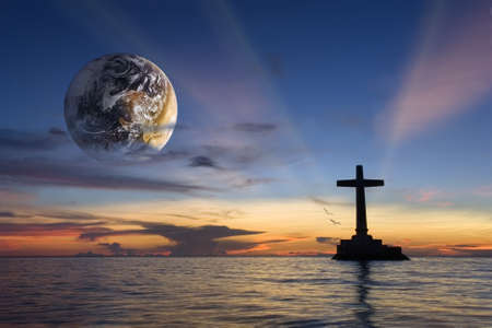 Colorful tropical marine sunset with a large concrete cross silhouette and a globe over Sunken Cemetery memorial, Camiguin, Philippines. Globe courtesy NASA.の写真素材