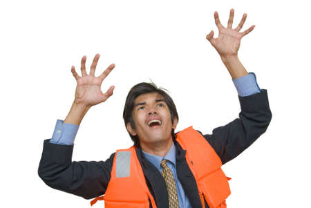 Young desperate Asian executive or corporate businessman in suit, necktie and life vest grasping upwards in the air with a horrified facial expression, attempting to escape imminent danger. Isolated over white.の写真素材