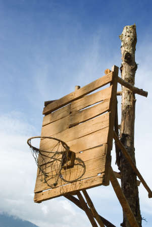 Homemade vintage backboard of wood planks with rusted nails and rusted basket for basketball play in a poor rural Western village.の写真素材