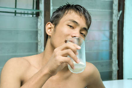 Portrait of young Asian male finished drinking from a glass.の写真素材