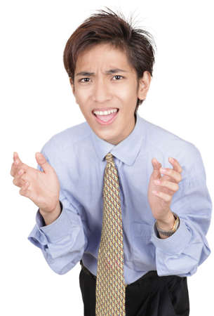 Oriental young businessman with alarmed and urgent facial expression leaning forward with a begging and startled hands gesture. Isolated over white.の写真素材