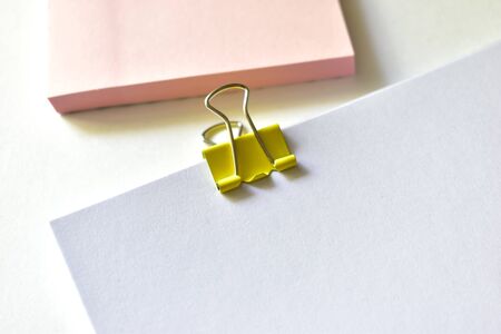 Metal colored stationery clips are attached to the Notepad and paperの写真素材
