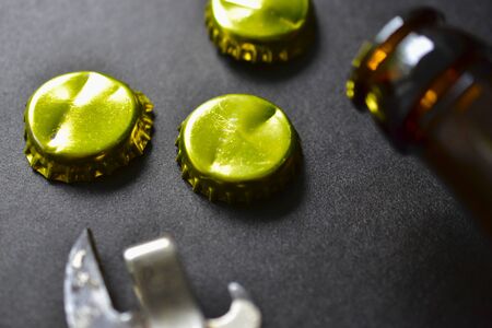 Empty beer bottle opener and gold bottle capsの写真素材