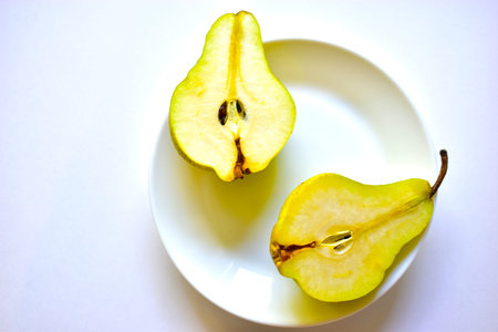 Fruit of a cut green pear on a white plate