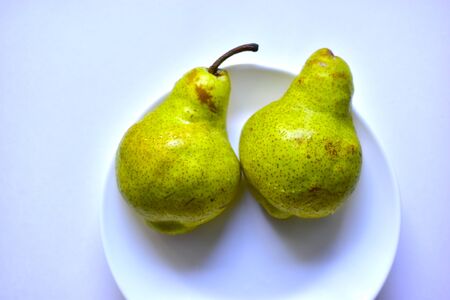 Fruit of a cut green pear on a white plateの写真素材