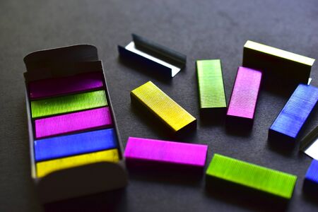Multi-colored stapler staples on a black backgroundの写真素材