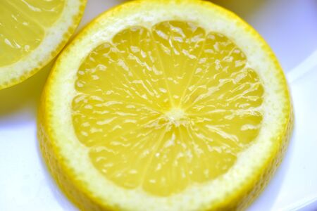 Cut the slices of ripe yellow lemons with sugarの写真素材