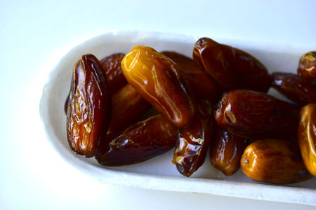 Dates are ripe and delicious on a white plastic backing