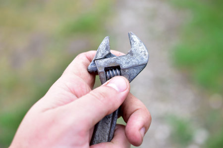 A small shiny wrench in the hands of the master