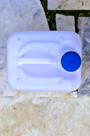 White plastic canister with blue lid in different positionsの写真素材