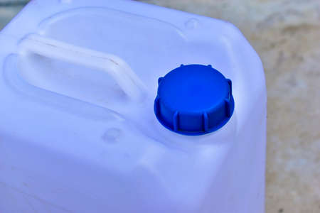 White plastic canister with blue lid in different positionsの写真素材