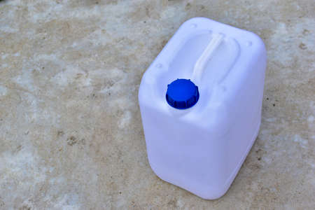 White plastic canister with blue lid in different positionsの写真素材