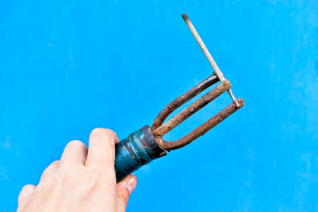 Handle holder of the welding machine in hand on a blue backgroundの写真素材