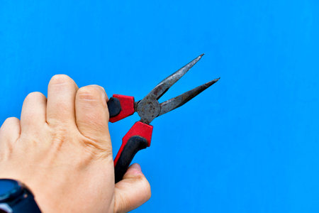 Iron red pliers pliers in hand for electrical installation