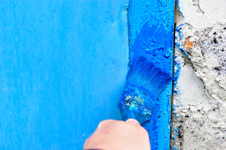 Painting iron surfaces with a blue paint brush