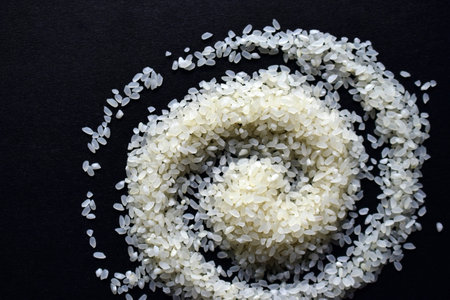 White rice curled into a curl on a black background