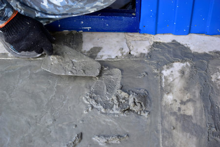 Working on concrete with a trowel leveling the surface