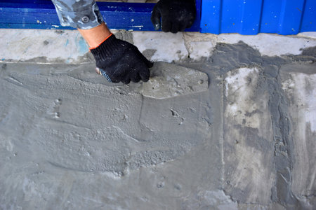Working on concrete with a trowel leveling the surface
