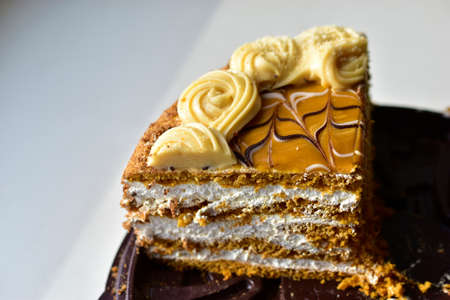 A piece of honey cream dark cake close upの写真素材