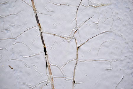 The iron surface is painted with white paint with cracksの写真素材
