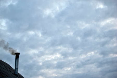 Iron chimney in the house with smokeの写真素材