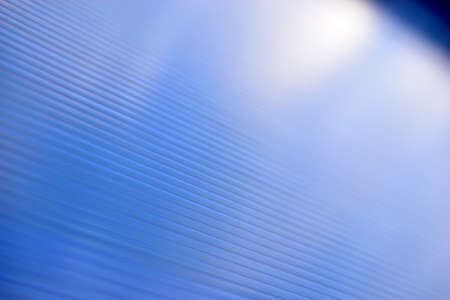 Blue surface of striped polycarbonate with a reflection of the blue distance of the cityの写真素材