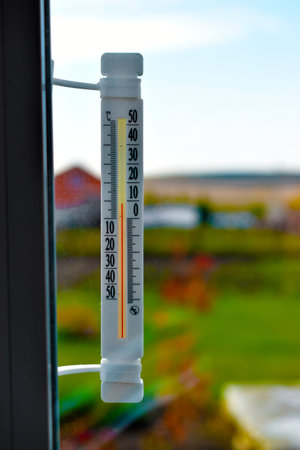 White thermometer attached to a white window