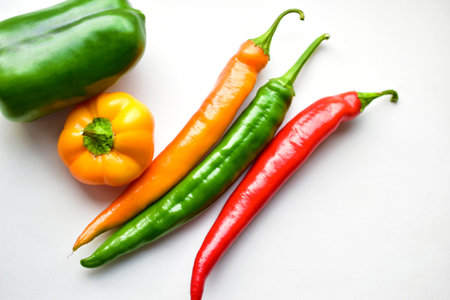 Regular and capsicum yellow and green pepper on a white background
