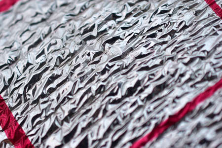 Silver thermal insulation material with red stripesの写真素材