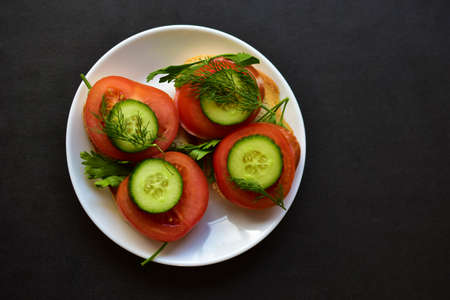 Diet sandwiches with greens, cucumber and tomato on a white plateの写真素材