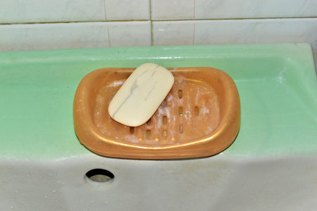 Plastic soap dish with soap in a dirty bathroom