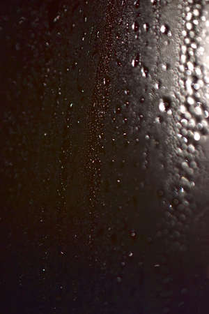 Glistening drops on the glass. Silvery drops in the bathroom. Transparent fog on the glass in drops, and the pattern of them.の写真素材
