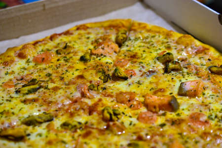 Round delicious sea pizza with seafood in a boxの写真素材