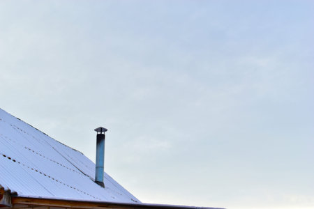 The iron chimney pipe that is covered with snow in winter