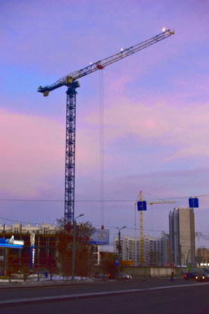 Construction of houses with tower cranes in the evening cityの写真素材