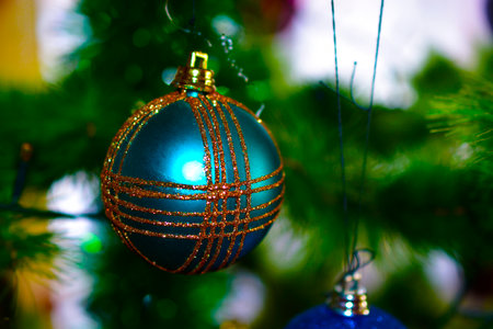Beautiful multi-colored Christmas toys on the holiday tree with reflections of lightの写真素材