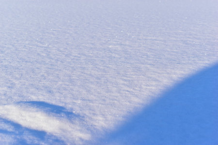 Snowy surface in winter with shadows in the eveningの写真素材